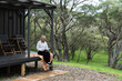© LisaGageler - Woman reading a book on the deck of a tiny house and relaxing in the Australian bush