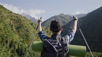 view from behind of a senior tourist with a backpack looking at the nature, and enjoying his hiking 
