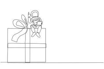 Poster - continuous one line drawing young energetic astronaut sitting on giant gift box holding laptop raise