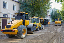 Road Construction Equipment: Excavators, Asphalt Rollers, Bulldozers On A City Street With The Road Surface Removed. Equipment For Repair And Laying Of Road Surfaces
