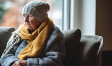 A Senior Person Wrapped Up In A Scarf And Hat During Winter. Cost Of Living Heating Gas Bill