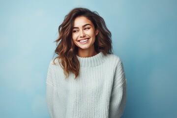 Wall Mural - Cheerful young woman in winter outfit looking at camera and smiling.