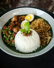 Close-up Of A Traditional Breakfast Of Rice, Egg, Shoestring Fries And Chicken (Nasi Balap Puyung), Lombok, Indonesia