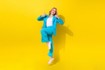 Wall Mural - Full size photo of cheerful good mood girl dressed blue jacket trousers jumping showing okey approve isolated on yellow background