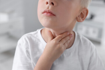 Wall Mural - Endocrine system. Little boy doing thyroid self examination indoors, closeup