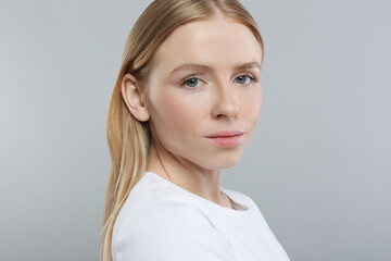 Wall Mural - Portrait of beautiful young woman on grey background