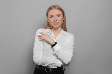 Wall Mural - Portrait of beautiful young woman in white shirt on grey background