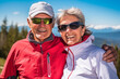 Happy smiling elderly couple with sunglasses hiking in the Alp mountains.