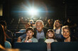 © Marko Geber - Multi-generational family engrossed in a captivating movie at the theater