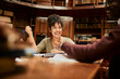 © Marko Geber - Enthusiastic student discussing her ideas in a university library