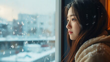 冬と女性、帰宅後に外の雪を見る日本人女性