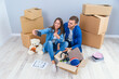 © gorynvd - Young couple taking selfies in their new home while sitting among cardboard boxes. Happy attractive young couple is moving, making a selfie, cuddling and smiling.
