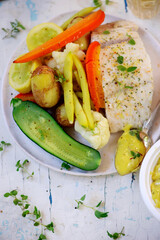 Wall Mural - Poashed cod with vegetables and aioli .top veiw