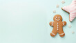 Christmas gingerbread man in a glass jar and a cup of coffee on a blue background.