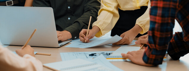 Professional engineer team discussion about house design on meeting table with architectural equipment and blueprint scatter around at modern office. Focus on hand. Closeup. Delineation.