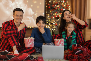 Canvas Print - Happy family with popcorn watching Christmas movie on laptop at home