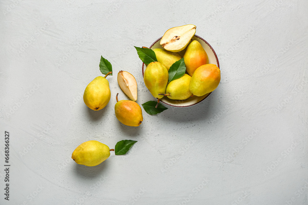 Bowl with fresh pears and leaves on white background