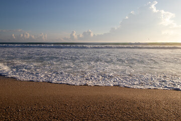 Wall Mural - Waves on a sandy beach in the morning