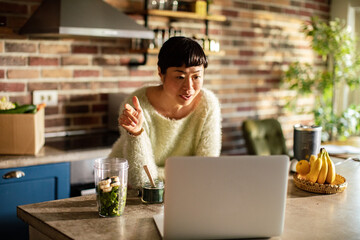 Young female nutritionist working with a client on video call from a laptop at home