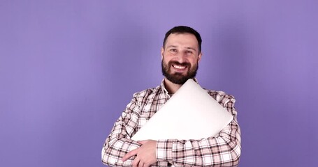 Portrait of smiling bearded man posing isolated on purple background and holding laptop. Studio portrait.