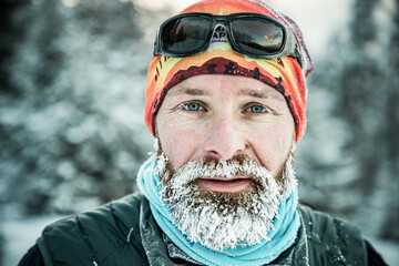 Wall Mural - trail runner with frozen beard training in winter landscape