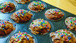 Delicious muffins with colorful sprinkles. Homemade cup cakes, sweet dessert, unhealthy food. Close up with baking tray.