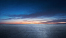 Black Asphalt Floor Background And Dark Blue Night Sky Sunset Horizon With Subtle Clouds
