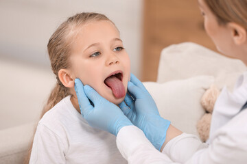 Canvas Print - Doctor in gloves examining girl`s oral cavity indoors