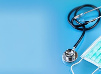 pills and medical equiupments including stethoscope, syringe at border on light blue background, pan