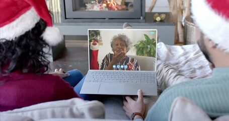 Poster - Happy diverse couple and senior mother having christmas laptop video call, slow motion