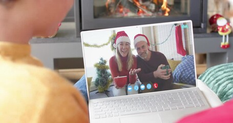 Poster - Happy caucasian couple and male friends having christmas laptop video call, slow motion