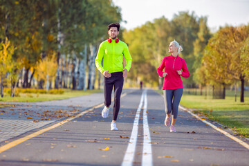  One Caucasian Positive Running Couple During Happily Jogging Outside as Runners Training Outdoors Working Out in City As Fitness Couple.