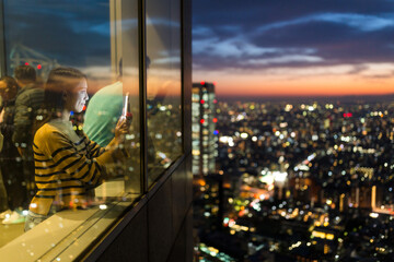 Canvas Print - Woman take photo inside building terrace at night