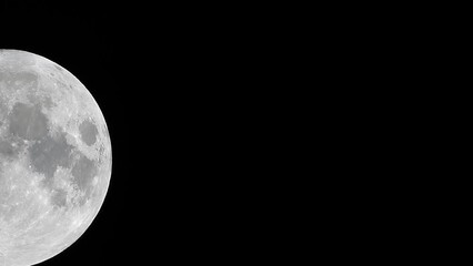 Wall Mural - Glowing huge full moon as seen from earth through the clouds against starry night sky. Large full moon moves across the sky, moon makes its way from bottom left frame to top right.