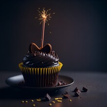 Birthday Cupcake With Chocolate Ganache Or Frosting Or Icing With Candle Or Sparkler For Celebration Against Dark Background With Copy Space