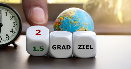 hand turns dice and changes the expression '1.5 grad ziel' (1.5 degree target) to '2 grad ziel' (2de