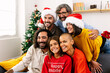 © Xavier Lorenzo - Smiling portrait of three generation family sitting together on sofa on christmas celebration. Grandfather, mother, father, son, daughter and grandchildren posing for photo.