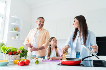 Poster - Photo of charming sweet wife husband little girl preparing tasty dinner frying vegetables indoors apartment kitchen