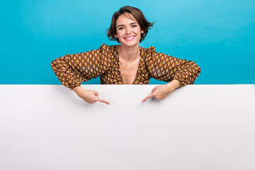 Poster - Portrait of pretty positive lady toothy smile indicate fingers empty space ad poster isolated on blue color background