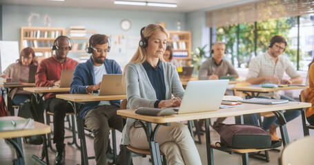 Leinwandbilder - Multiethnic Women and Men of Different Age Acquiring New Academic Skills in Modern Classroom. Diverse Mature Students Doing an Audio Language Exam, Listening to Assignments in Headphones.