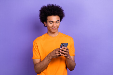 Wall Mural - Portrait of positive attractive man use smart phone blogging empty space isolated on purple color background