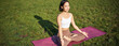 Portrait of smiling asian woman meditating, doing yoga on fresh air, relaxing on rubber mat, exercising in park, breathing air, being calm