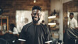 © BlazingDesigns - Portrait of handsome young african american barber posing with his arms crossed inside a barbershop.