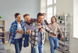Group of happy joyful excited young men hugging, celebrating success, and having fun as they congratulate successful friend on getting married, divorced, buying new car, or getting good well paid job