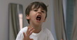 Angry child yelling and screaming at camera in super slow-motion. Upset male caucasian kid in tantrum mode