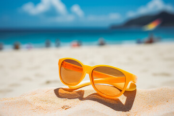 Sunscreen on sandy beach with sunglasses. Summer concept.