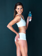© Tamani Chithambo/peopleimages.com - Attractive woman, portrait and water bottle for body diet, health and wellness against a studio background. Female person or gorgeous model posing in underwear showing off glutes, buttocks or butt