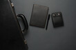 Leather suitcase with a notebook and wallet on a dark background. Business concept. Top view