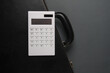Leather suitcase with calculator on a dark background. Business concept. Top view