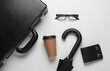Leather suitcase with coffee cup, purse, eyeglasses on white background. Business concept. Top view. Flat lay